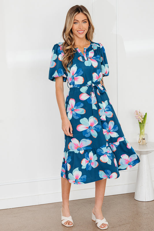 Robe longue ceinturée bleue à imprimé floral, manches courtes bouffantes et ourlet volanté